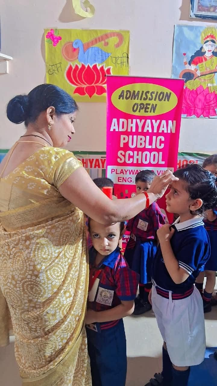 A teacher blessing a student with a tilak before class