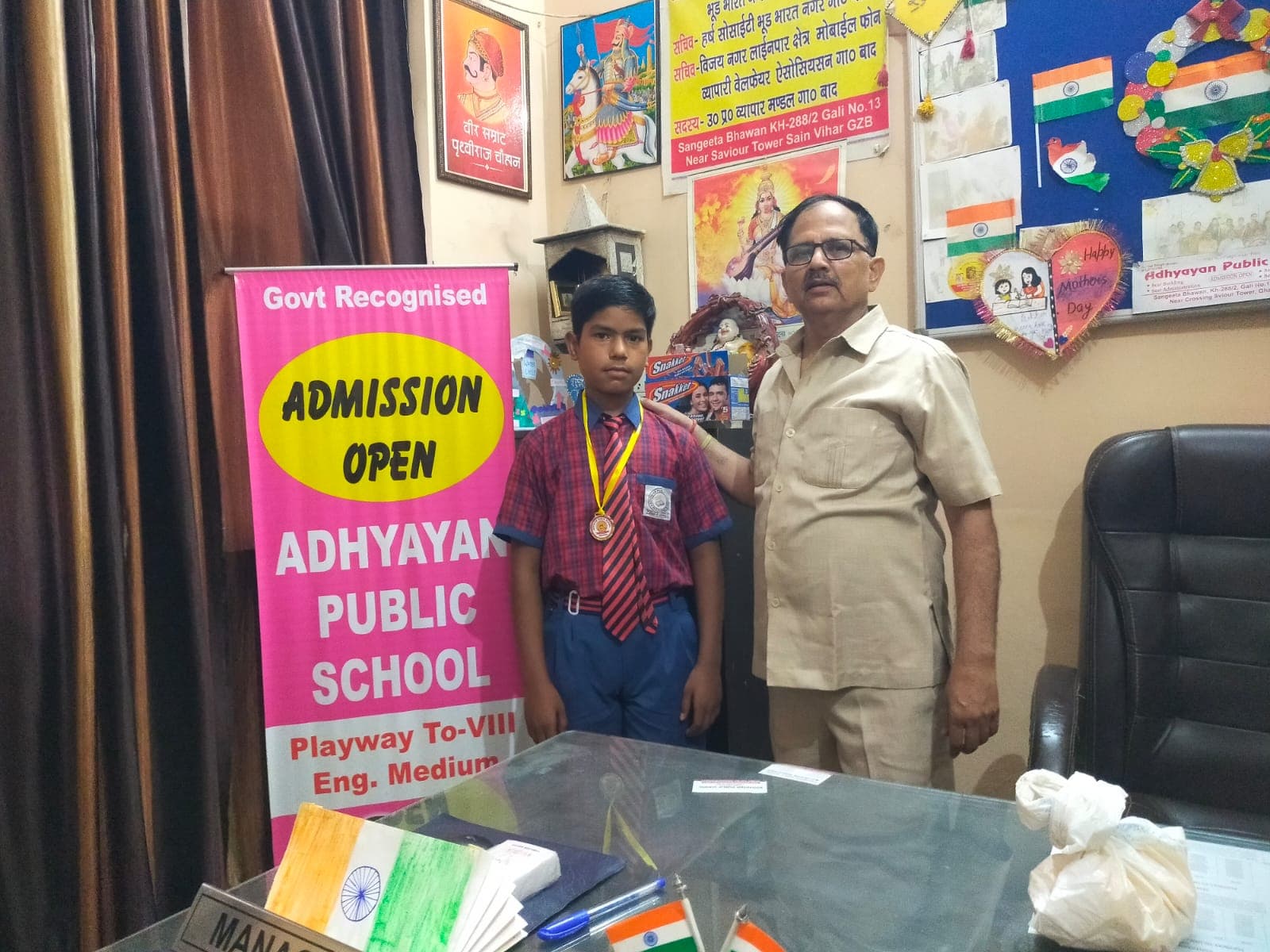 A student proudly wearing a medal alongside the school founder